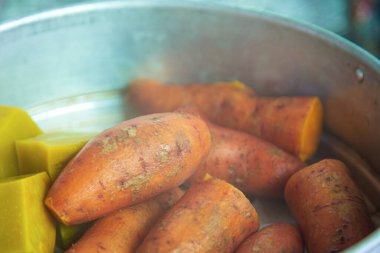 Alüminyum Tayland yemek tenceresinde pişirilmiş tatlı patatesleri ve kabakları kapatın..