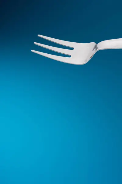 Fork in blue background — Stock Photo, Image
