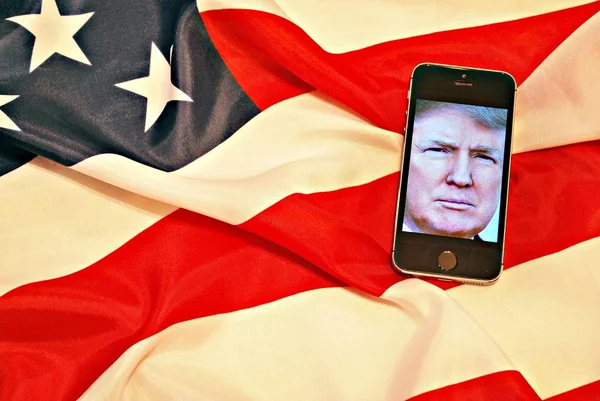 唐纳德·特朗普智能手机触摸屏和我们的旗帜. — 图库照片