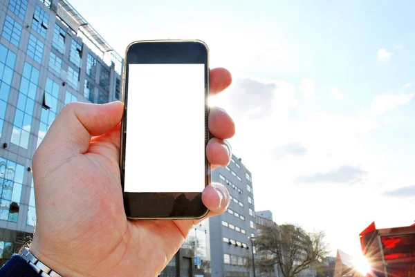 มือถือสมาร์ทโฟน เมืองในพื้นหลัง — ภาพถ่ายสต็อก