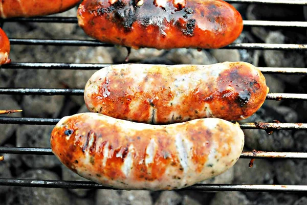 Grilling sausages on barbecue grill. BBQ in the garden. Bavarian sausages. Stock Photo