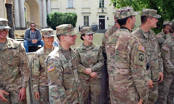 Amerikalı bir asker üniformalı ve sivil adam el sıkışan takım elbiseli