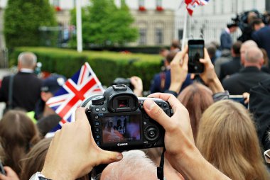 Bir grup insan cep telefonu, akıllı telefon ve dijital kamera kullanarak olayların fotoğrafını çekiyor.