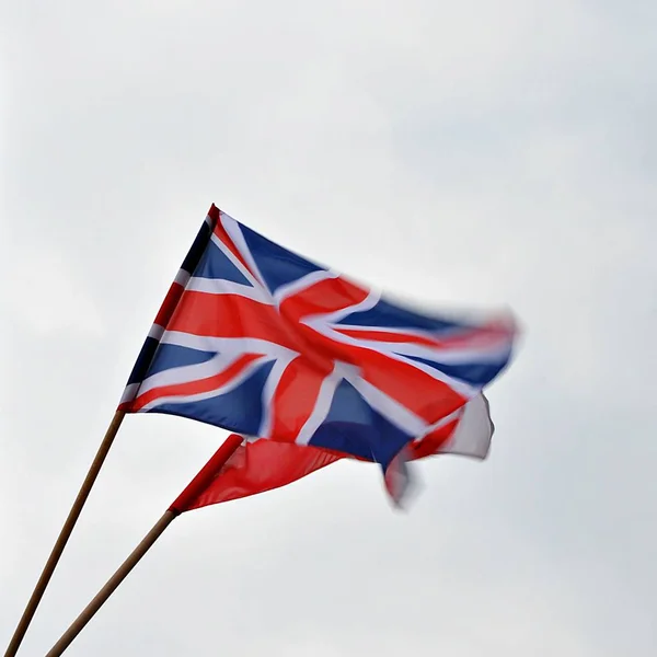 Bandiera dell'Unione che batte nel vento; Bandiera britannica Union Jack che batte nel vento contro un cielo estivo — Foto Stock