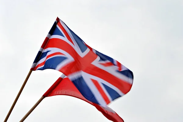Union vlajku ve větru; Britská vlajka vlajka letí ve větru proti letní oblohy — Stock fotografie