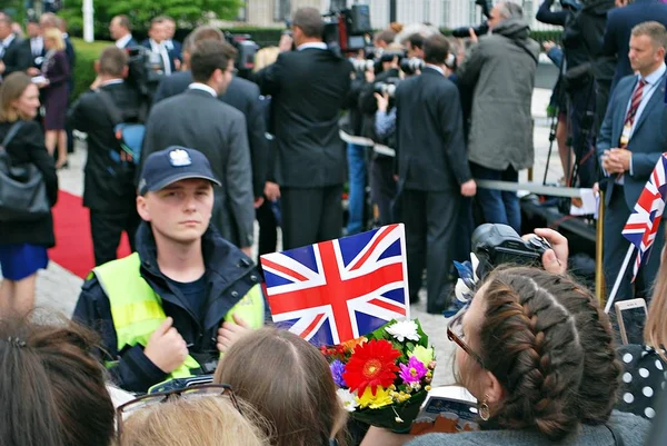 Personer som tar bilder av kungaparet. Människor höll Union Jack-flaggor och blommor — Stockfoto