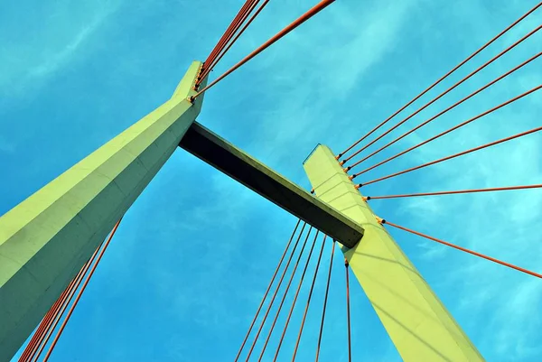 Пілони мостів на мотузках проти блакитного неба в хмарах — стокове фото