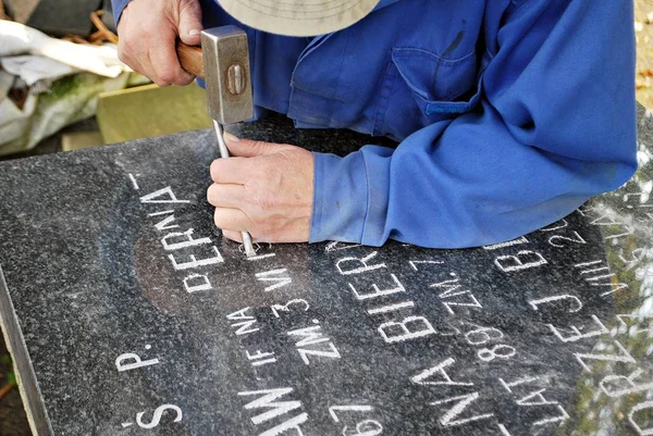 Craftsman working with chisel at tombstone — Stock Photo, Image