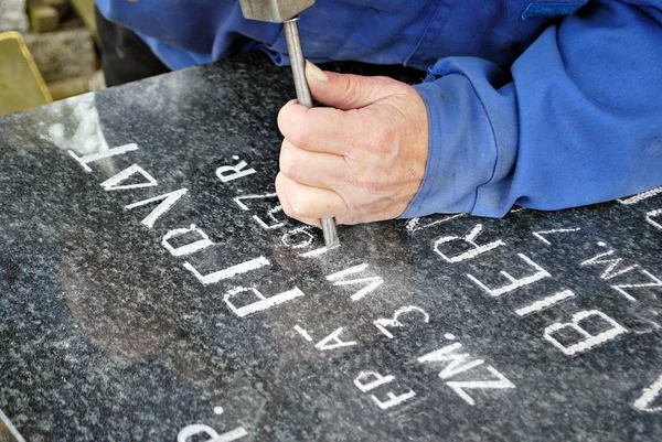 Craftsman working with chisel at tombstone — Stock Photo, Image