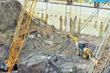 Prekast beton ayarlamak için şahmerdan kabilelerini işçisi bir inşaat yüksek bina alanında kazık