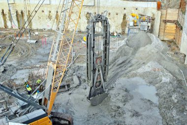 Prekast beton ayarlamak için şahmerdan kabilelerini işçisi bir inşaat yüksek bina alanında kazık