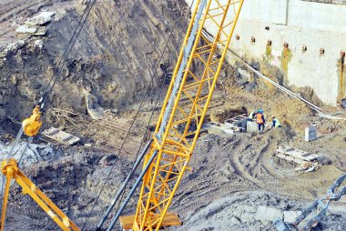Prekast beton ayarlamak için şahmerdan kabilelerini işçisi bir inşaat yüksek bina alanında kazık
