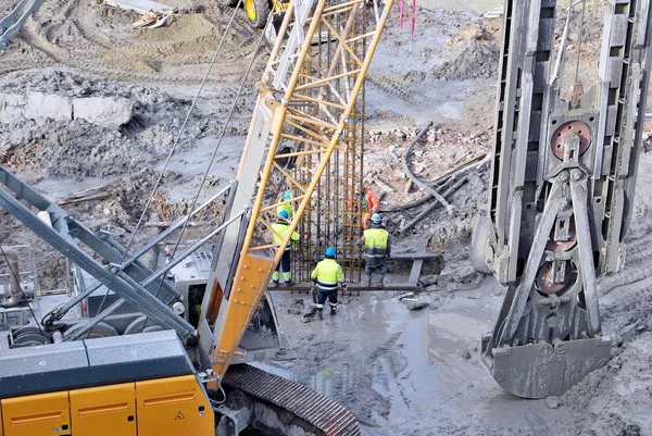 Worker working at pile driver works to set precast concrete piles in a construction high building area — Stock Photo, Image