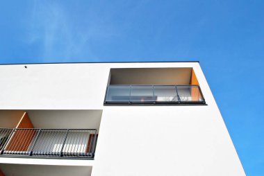 Mavi gökyüzü olan güneşli bir günde modern apartman binaları. Modern bir apartmanın cephesi