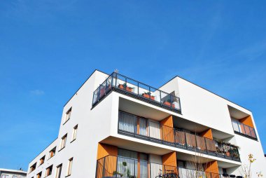 Mavi gökyüzü olan güneşli bir günde modern apartman binaları. Modern bir apartmanın cephesi