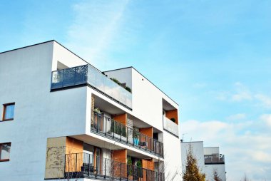 Mavi gökyüzü olan güneşli bir günde modern apartman binaları. Modern bir apartmanın cephesi