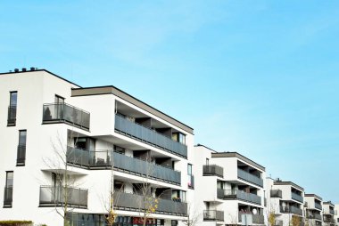 Mavi gökyüzü olan güneşli bir günde modern apartman binaları. Modern bir apartmanın cephesi