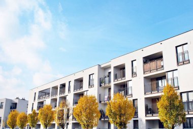 Mavi gökyüzü olan güneşli bir günde modern apartman binaları. Modern bir apartmanın cephesi