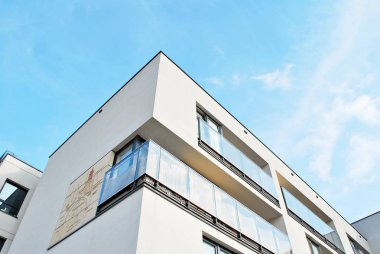 Mavi gökyüzü olan güneşli bir günde modern apartman binaları. Modern bir apartmanın cephesi