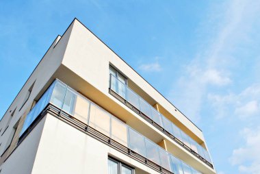 Mavi gökyüzü olan güneşli bir günde modern apartman binaları. Modern bir apartmanın cephesi