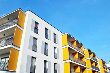 Mavi gökyüzü olan güneşli bir günde modern apartman binaları. Modern bir apartmanın cephesi