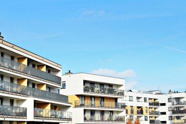 Mavi gökyüzü olan güneşli bir günde modern apartman binaları. Modern bir apartmanın cephesi