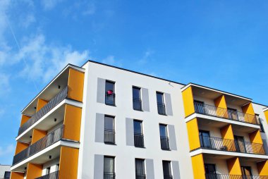 Mavi gökyüzü olan güneşli bir günde modern apartman binaları. Modern bir apartmanın cephesi