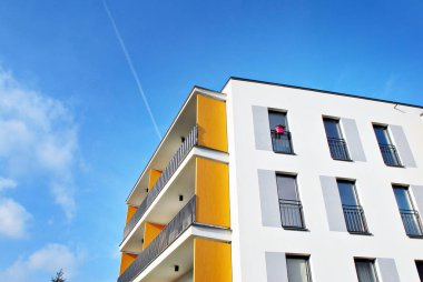 Mavi gökyüzü olan güneşli bir günde modern apartman binaları. Modern bir apartmanın cephesi