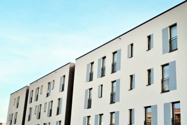 Mavi gökyüzü olan güneşli bir günde modern apartman binaları. Modern bir apartmanın cephesi