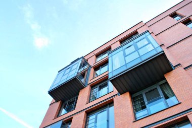 Mavi gökyüzü olan güneşli bir günde modern apartman binaları. Modern bir apartmanın cephesi
