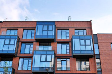 Mavi gökyüzü olan güneşli bir günde modern apartman binaları. Modern bir apartmanın cephesi