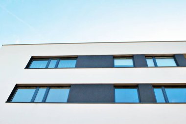 Mavi gökyüzü olan güneşli bir günde modern apartman binaları. Modern bir apartmanın cephesi