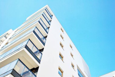 Mavi gökyüzü olan güneşli bir günde modern apartman binaları. Modern bir apartmanın cephesi
