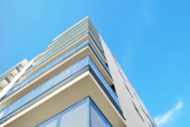Mavi gökyüzü olan güneşli bir günde modern apartman binaları. Modern bir apartmanın cephesi