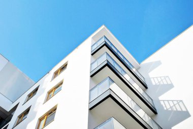 Mavi gökyüzü olan güneşli bir günde modern apartman binaları. Modern bir apartmanın cephesi