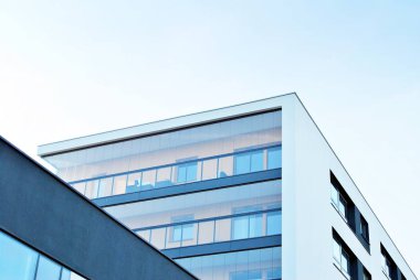 Mavi gökyüzü olan güneşli bir günde modern apartman binaları. Modern bir apartmanın cephesi