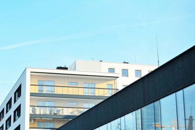 Mavi gökyüzü olan güneşli bir günde modern apartman binaları. Modern bir apartmanın cephesi