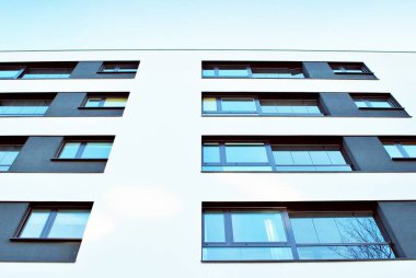 Mavi gökyüzü olan güneşli bir günde modern apartman binaları. Modern bir apartmanın cephesi