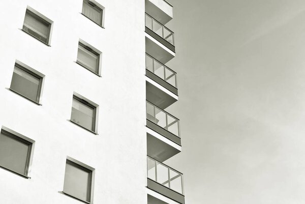 Modern apartment buildings on a sunny day with a blue sky. Facade of a modern apartment building. Black and white.