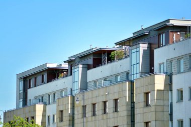 Mavi gökyüzü olan güneşli bir günde modern apartman binaları. Modern bir apartmanın cephesi