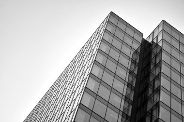 Gökyüzünün altındaki tonlu cam ve çelik yapılardan oluşan perde. Binanın bir parçası. Siyah ve beyaz.