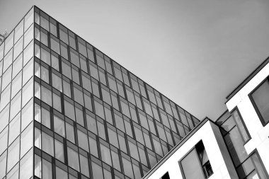 Gökyüzünün altındaki tonlu cam ve çelik yapılardan oluşan perde. Binanın bir parçası. Siyah ve beyaz.