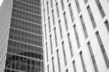 Gökyüzünün altındaki tonlu cam ve çelik yapılardan oluşan perde. Binanın bir parçası. Siyah ve beyaz.