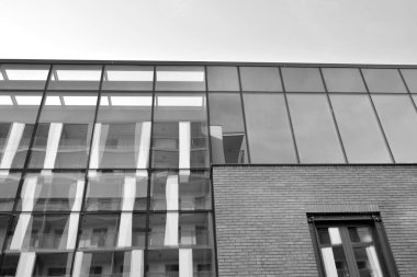 Gökyüzünün altındaki tonlu cam ve çelik yapılardan oluşan perde. Binanın bir parçası. Siyah ve beyaz.