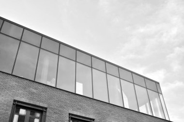 Gökyüzünün altındaki tonlu cam ve çelik yapılardan oluşan perde. Binanın bir parçası. Siyah ve beyaz.