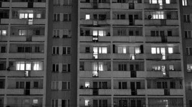 Geceleri apartmanın dışı pencerelerden gelen ışıklarla dolu. Siyah ve beyaz.
