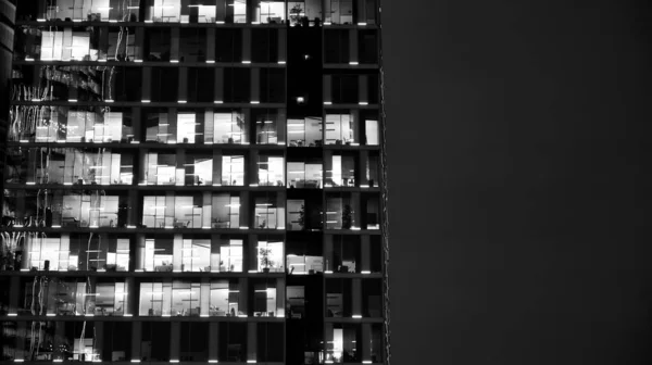 办公大楼的窗户在夜间照明 城市玻璃建筑立面设计的照明与反思 黑人和白人 — 图库照片