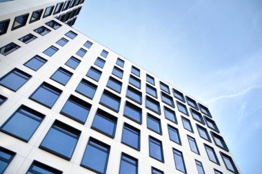 Modern Avrupa binası. Mavi gökyüzüne karşı birçok penceresi olan beyaz bir bina. Soyut mimari, modern şehir geometrisinin bir parçası.