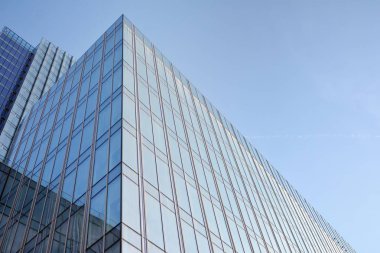 Çelik ve cam mavi gökyüzü ile modern ofis binası duvar yapılmış