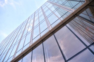 Çelik ve cam mavi gökyüzü ile modern ofis binası duvar yapılmış